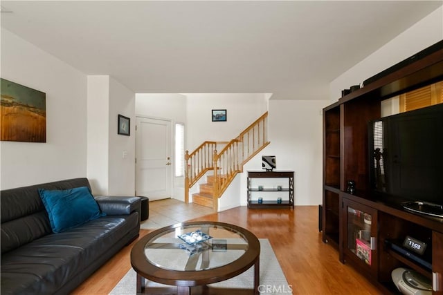 living room featuring stairs and light wood finished floors