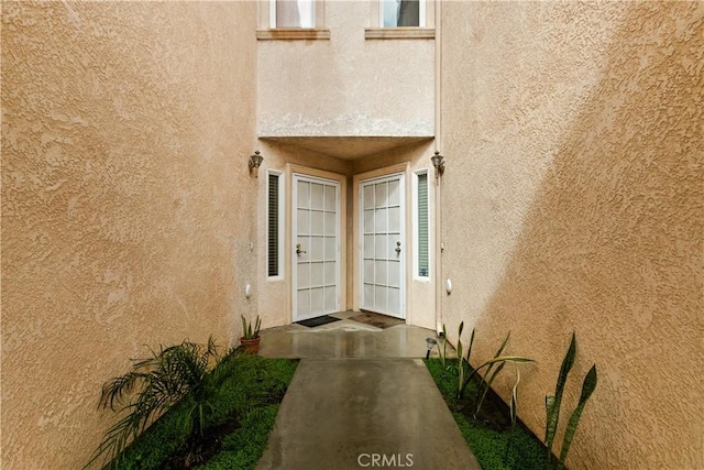 entrance to property featuring stucco siding