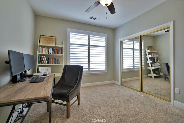 carpeted home office featuring a ceiling fan, visible vents, and baseboards