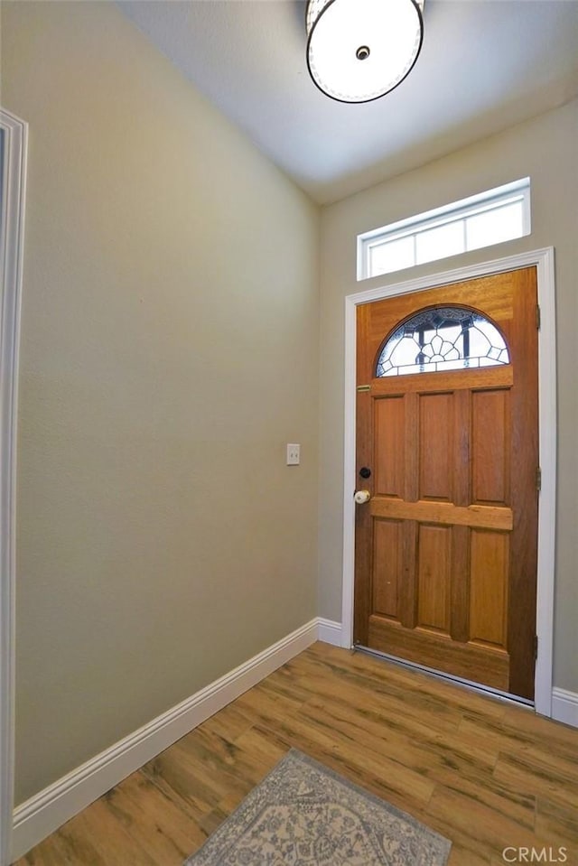 entryway with baseboards and wood finished floors