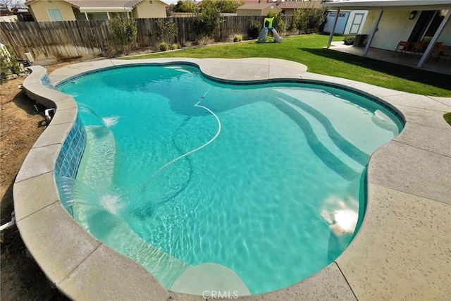 view of pool featuring a patio area, a fenced backyard, a fenced in pool, and a lawn