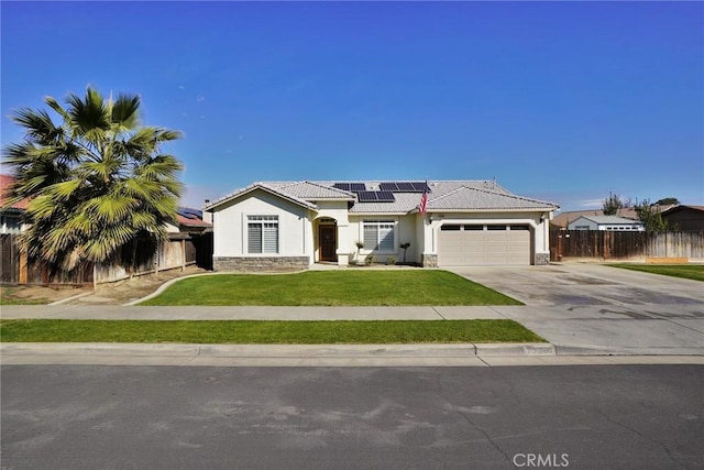 view of front of house with driveway, stone siding, fence, a front lawn, and stucco siding