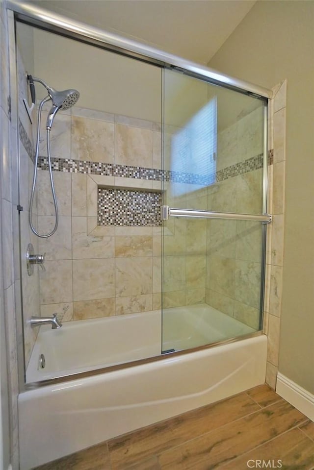 full bathroom featuring bath / shower combo with glass door, baseboards, and wood finished floors