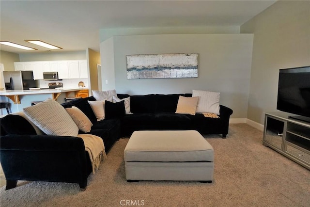 living room with light carpet and baseboards