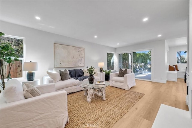 living area featuring recessed lighting, baseboards, and light wood-style flooring