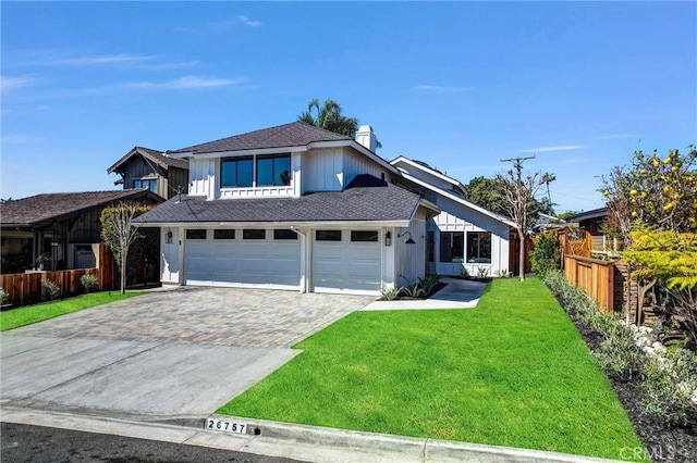 view of front of house with a front yard, fence, an attached garage, a shingled roof, and decorative driveway