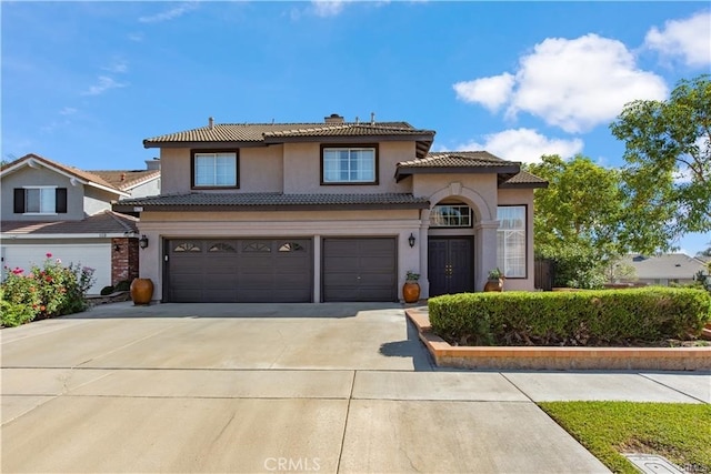 view of front of house featuring a garage, concrete driveway, a tiled roof, stucco siding, and a chimney