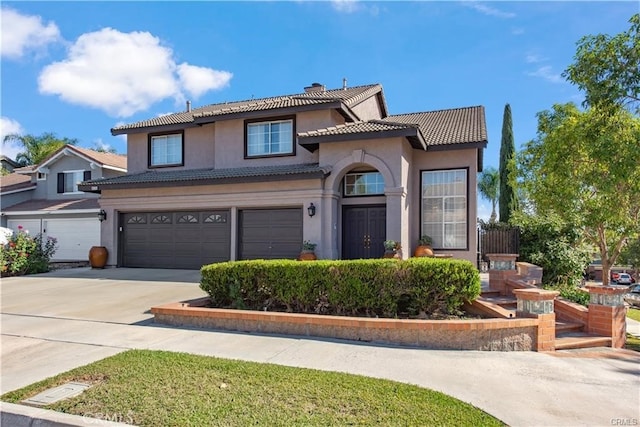 view of front of home with a garage, a tile roof, driveway, and stucco siding