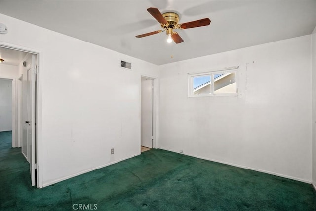 carpeted spare room featuring a ceiling fan and visible vents