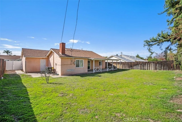 rear view of property featuring a yard, a fenced backyard, a patio, and stucco siding