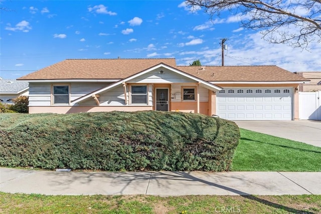 ranch-style home with roof with shingles, stucco siding, an attached garage, fence, and driveway