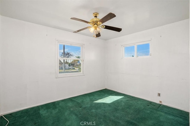 empty room featuring plenty of natural light, ceiling fan, and carpet