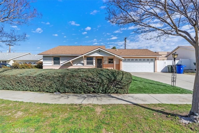 single story home with a garage, fence, concrete driveway, stucco siding, and a front lawn