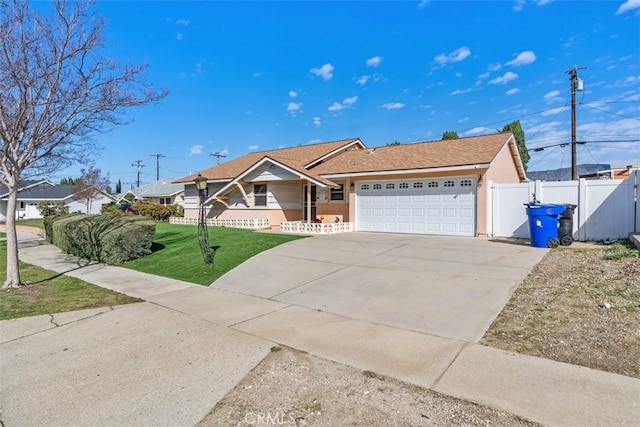 single story home featuring concrete driveway, an attached garage, a gate, fence, and a front yard