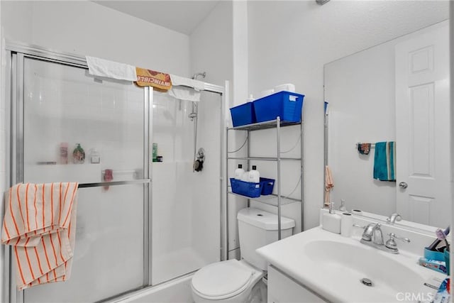 full bathroom featuring a stall shower, vanity, and toilet