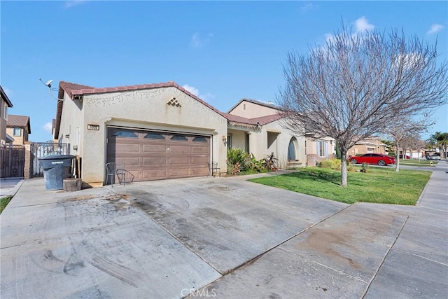 mediterranean / spanish-style home featuring a garage, driveway, fence, a front lawn, and stucco siding