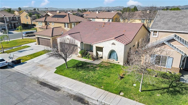 view of front of house featuring concrete driveway, a residential view, a tiled roof, an attached garage, and stucco siding