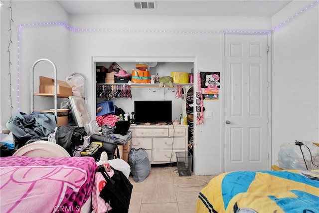 bedroom with a closet, light tile patterned flooring, and visible vents