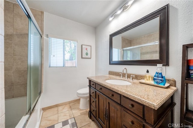 bathroom with combined bath / shower with glass door, vanity, toilet, and tile patterned floors