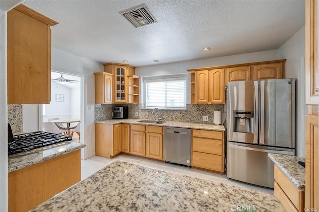 kitchen featuring visible vents, appliances with stainless steel finishes, a sink, open shelves, and backsplash