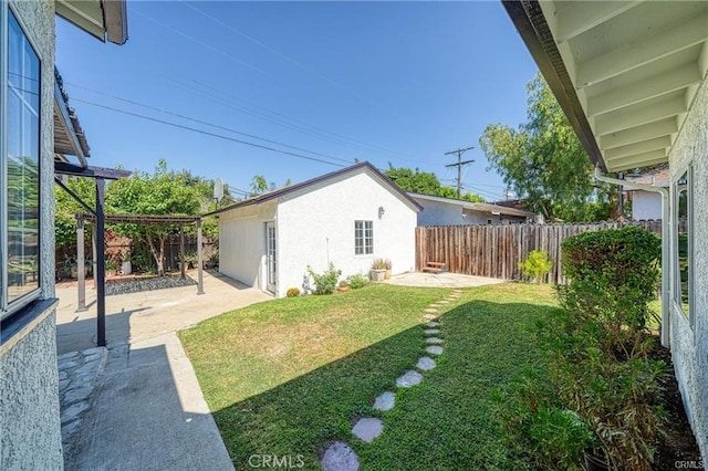 view of yard with a patio area, a fenced backyard, and an outdoor structure