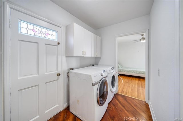 laundry room with dark wood-type flooring, washer and dryer, and cabinet space