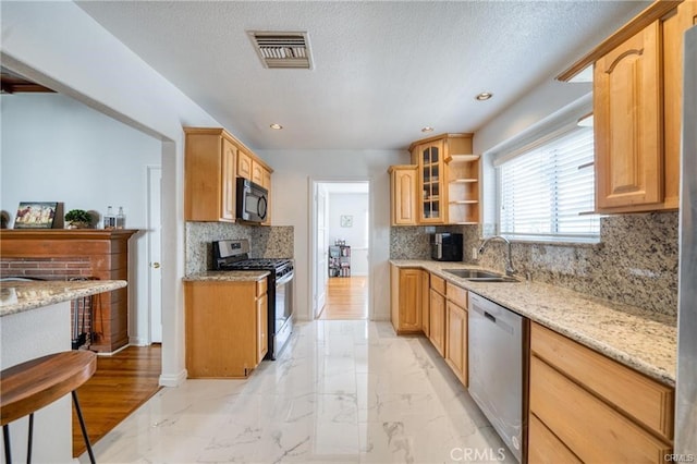 kitchen with marble finish floor, stainless steel appliances, visible vents, glass insert cabinets, and a sink