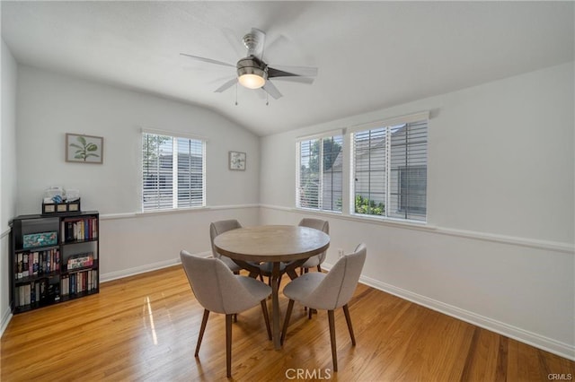 dining area featuring vaulted ceiling, baseboards, a ceiling fan, and light wood-style floors