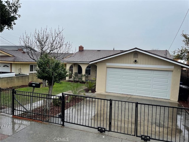 view of front of property featuring driveway, a front lawn, a fenced front yard, and an attached garage