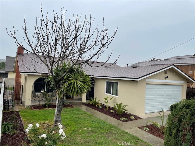 ranch-style home with an attached garage, a shingled roof, fence, stucco siding, and a front lawn