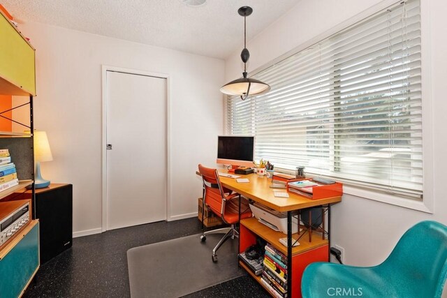 office area with baseboards, a textured ceiling, and speckled floor