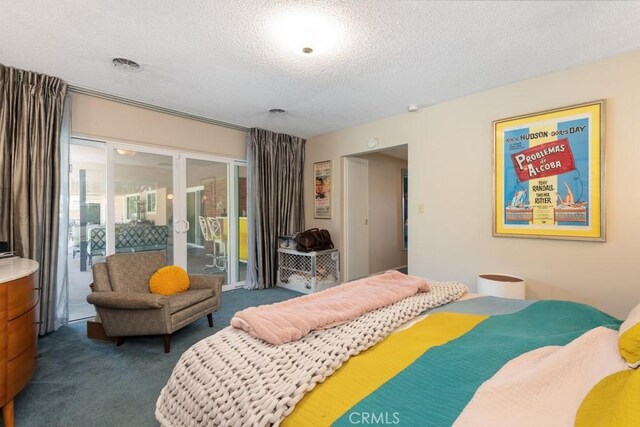 bedroom featuring access to outside, visible vents, dark carpet, and a textured ceiling