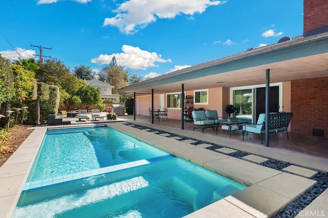 pool with a patio area and an outdoor living space