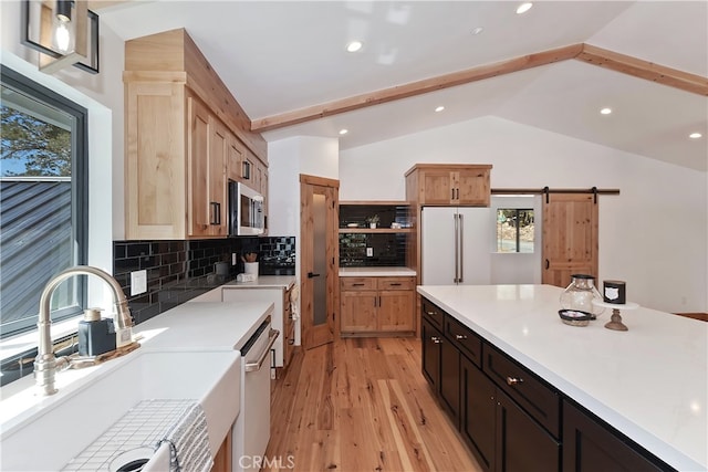 kitchen with open shelves, stainless steel microwave, freestanding refrigerator, a sink, and dishwasher