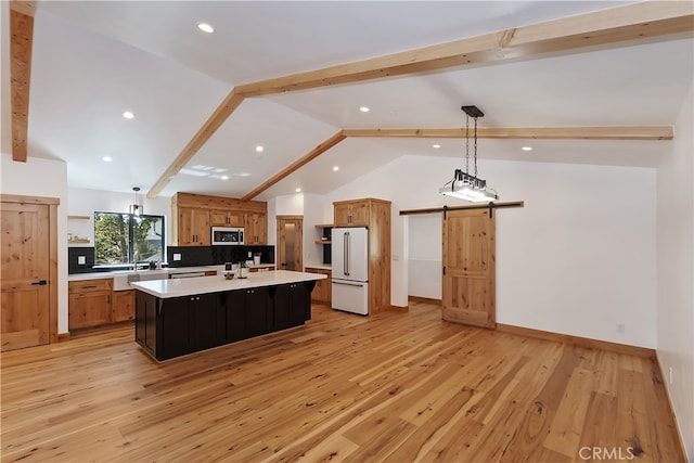 kitchen featuring open shelves, light countertops, stainless steel microwave, high end white fridge, and a barn door