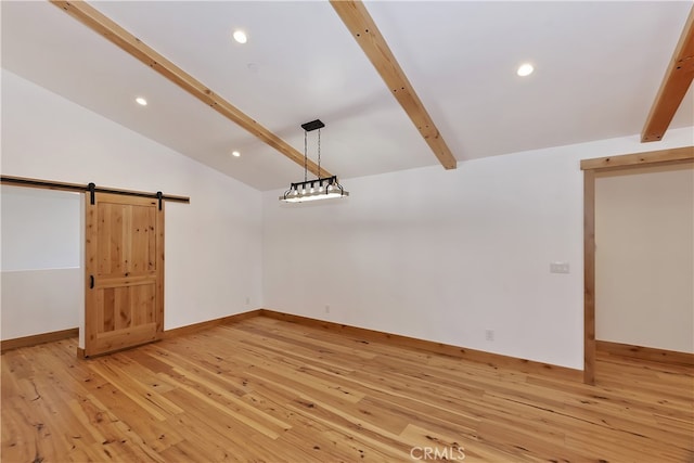 unfurnished room featuring vaulted ceiling with beams, a barn door, recessed lighting, and light wood-style floors