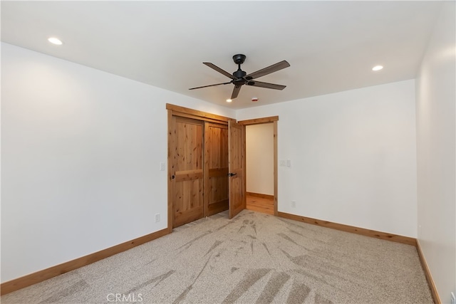 empty room with light carpet, recessed lighting, a ceiling fan, and baseboards