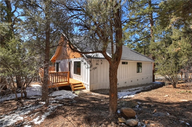 view of front facade featuring a deck, crawl space, and roof with shingles