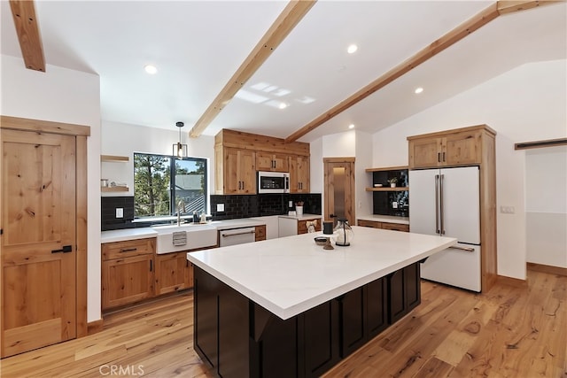 kitchen with a sink, white fridge, open shelves, tasteful backsplash, and stainless steel microwave