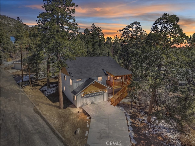 view of front of house featuring a shingled roof and concrete driveway