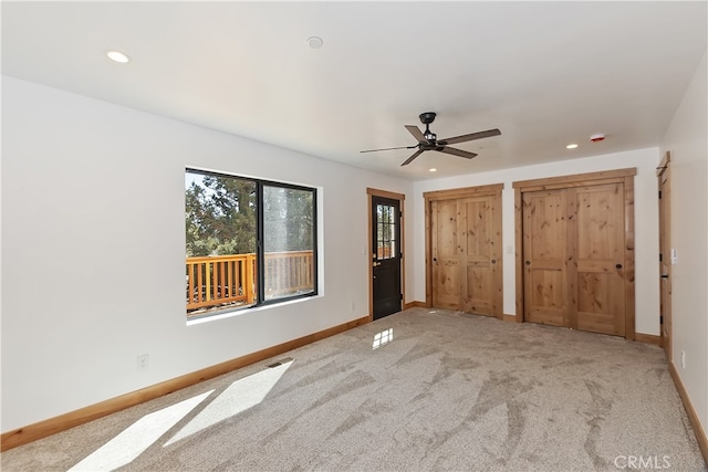 unfurnished bedroom featuring two closets, recessed lighting, a ceiling fan, carpet flooring, and baseboards