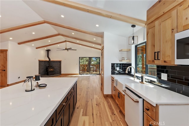 kitchen with vaulted ceiling with beams, tasteful backsplash, light wood-style floors, a wood stove, and white appliances