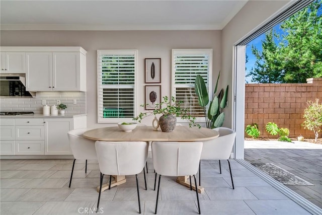 dining room featuring light tile patterned floors and ornamental molding