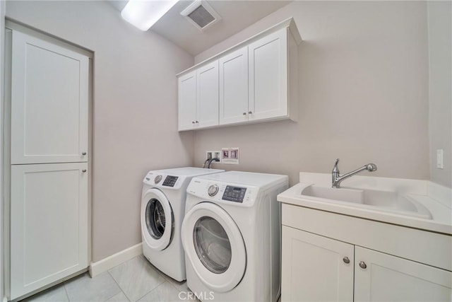 laundry area featuring cabinet space, visible vents, a sink, independent washer and dryer, and baseboards