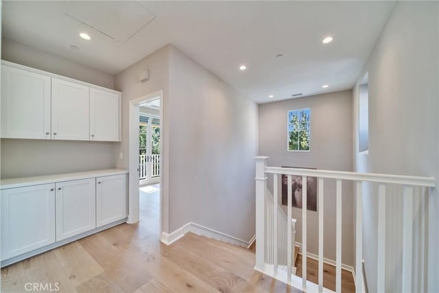 hall with baseboards, recessed lighting, light wood-style flooring, and a healthy amount of sunlight