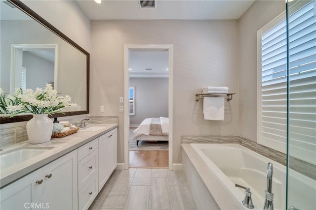 full bathroom with double vanity, visible vents, ensuite bathroom, a sink, and a bath