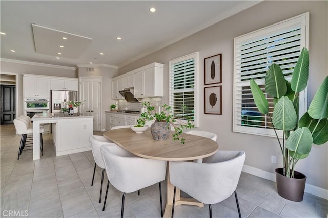 dining room with baseboards, ornamental molding, and recessed lighting