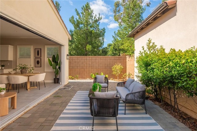 view of patio with outdoor dining area, fence, and an outdoor living space