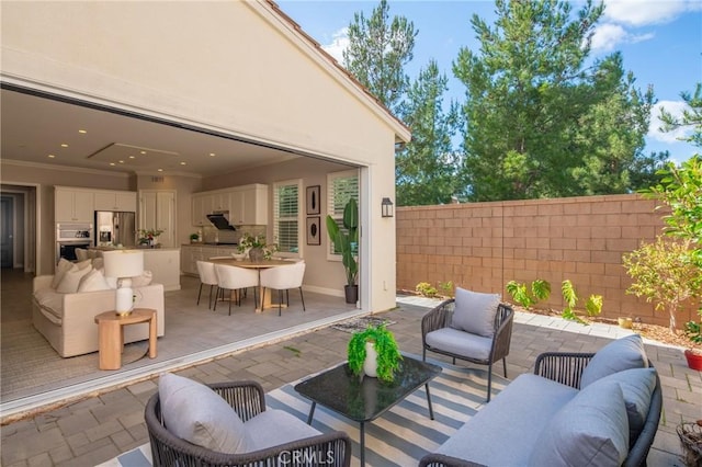 view of patio with fence, an outdoor hangout area, and outdoor dining space