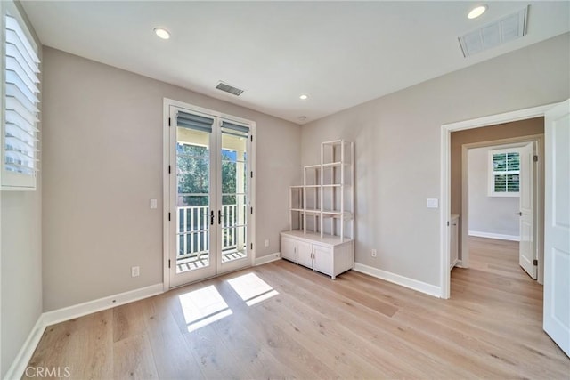 doorway featuring light wood-type flooring, baseboards, visible vents, and french doors